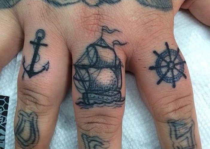 手指黑色的船锚和帆船与船舵纹身图案