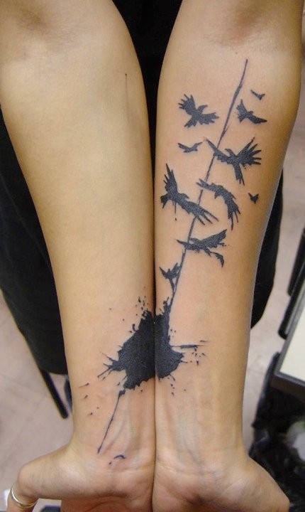小臂惊人的黑色小鸟和泼墨纹身图案