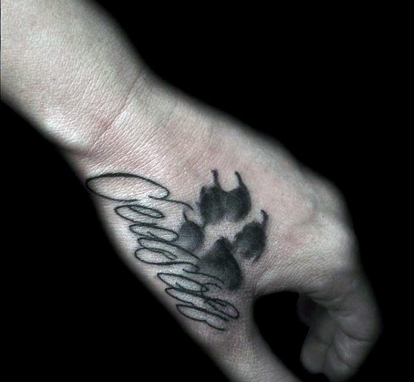 手背黑色的纪念动物爪印和字母纹身图案