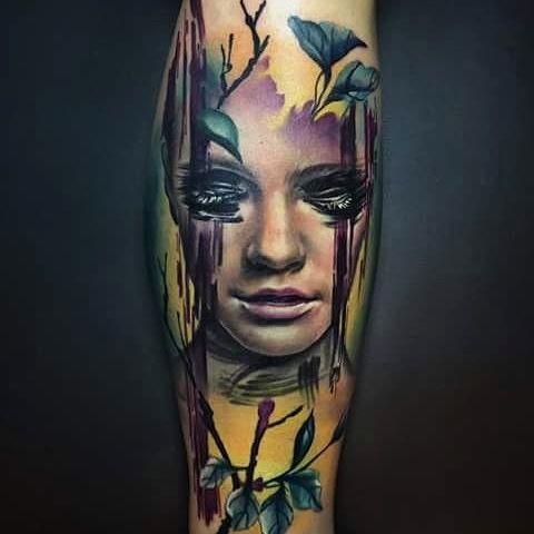 手臂彩色的女性肖像与树叶纹身图案
