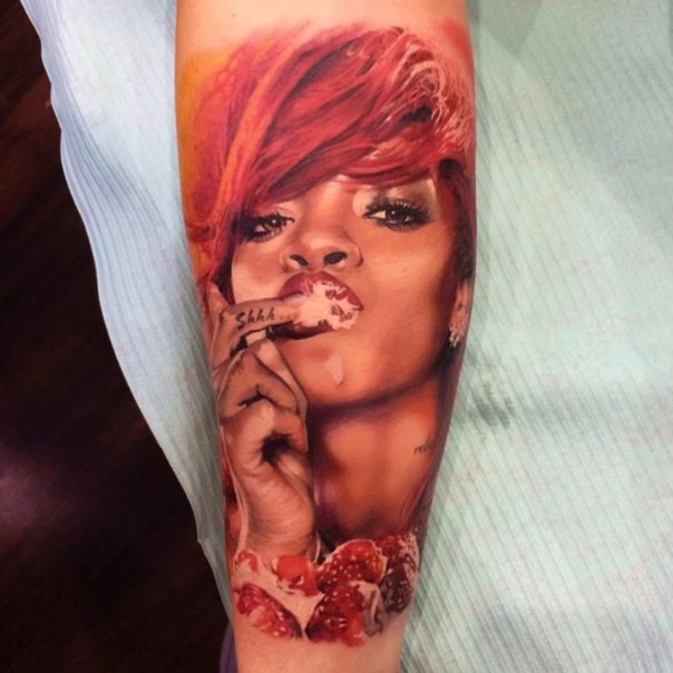 手臂上的彩色蕾哈娜肖像纹身图案