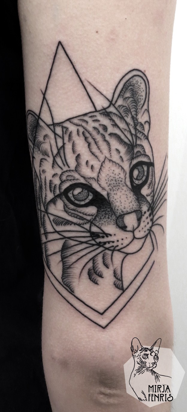 手臂黑色的点刺猫脸与几何纹身图案
