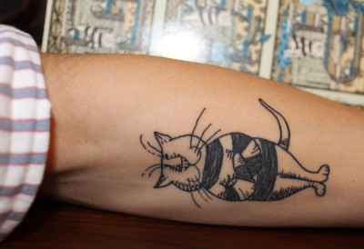 手臂卡通风格的滑稽猫黑色纹身图案