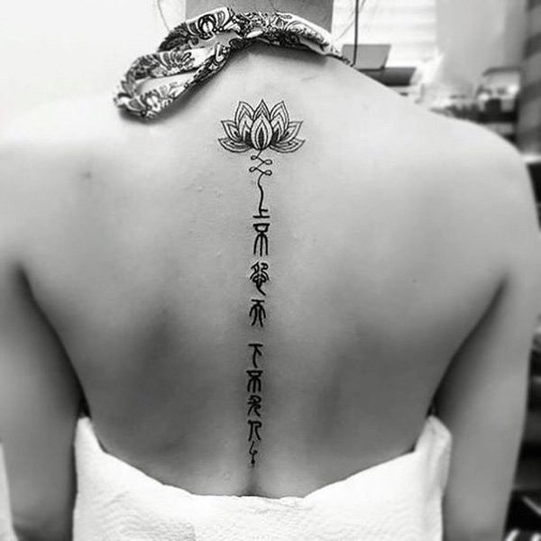 女生背部黑色莲花与字符纹身图案