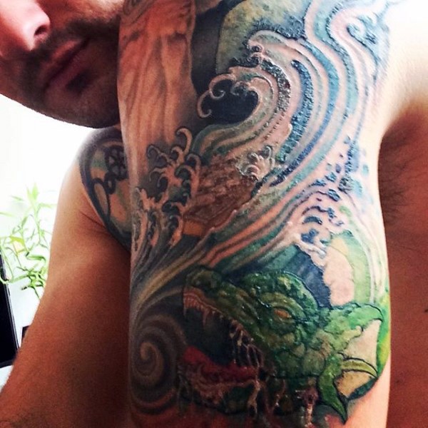 手臂亚洲风格的五彩龙和波浪纹身图案