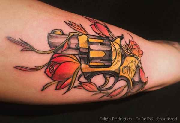 手臂彩色的小手枪与花朵纹身图案
