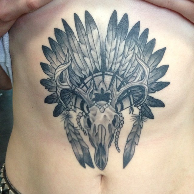 腹部印度风格的动物头骨与鸟类头盔纹身图案