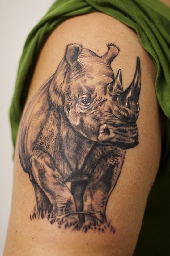 手臂犀牛站在草地上纹身图案
