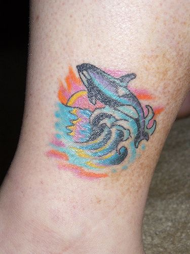 跳跃的虎鲸和日落彩色纹身图案