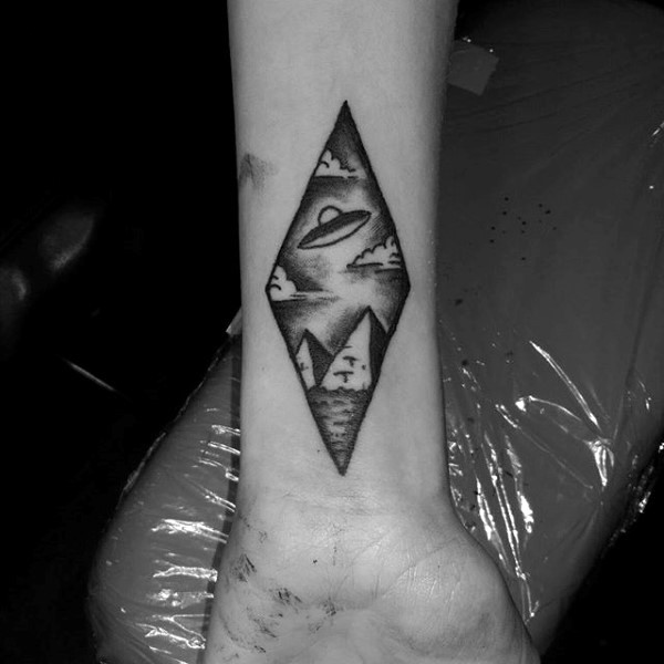手腕微小的黑色飞船与金字塔纹身图案