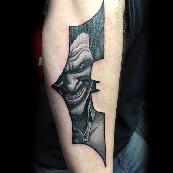 蝙蝠侠标志形状与微笑小丑黑色手臂纹身图案