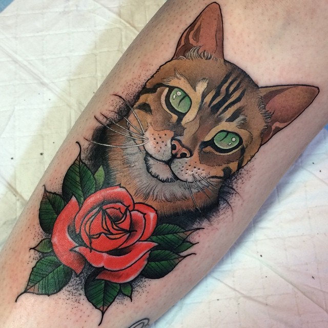 手臂彩色的猫头像和红玫瑰纹身图案