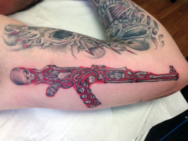 彩色骷髅骨架组成的步枪手臂纹身图案