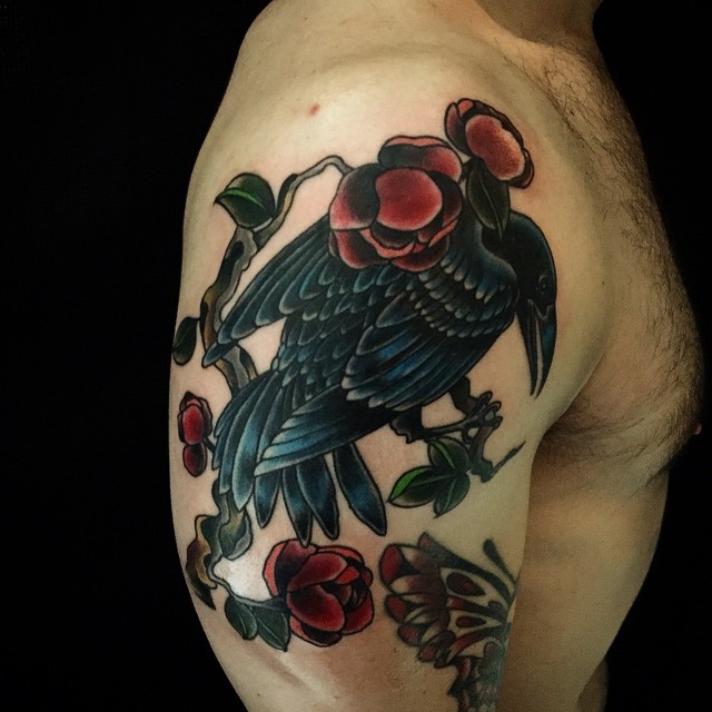 大臂生动彩色的乌鸦与红玫瑰纹身图案