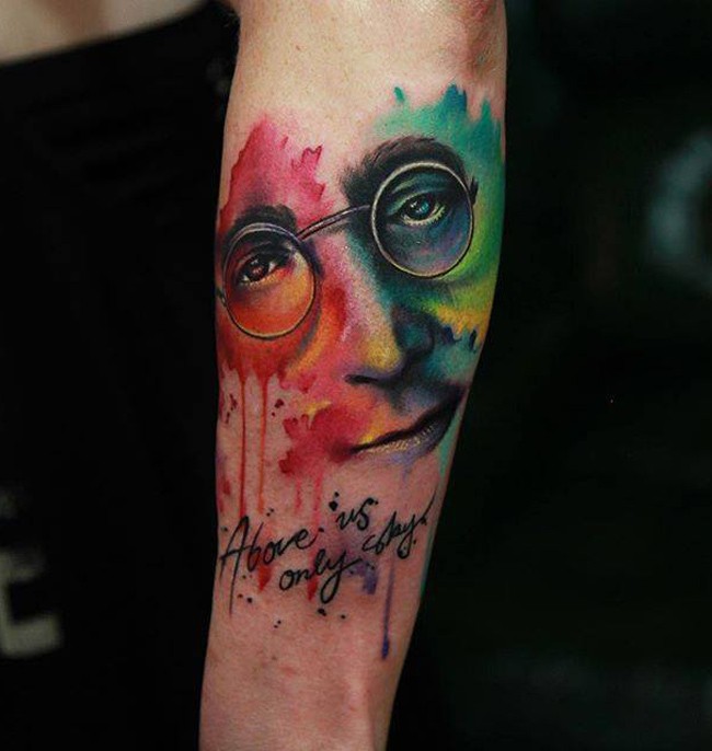 手臂彩色的列侬肖像和字母纹身图案