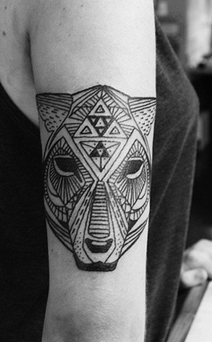 手臂上的黑色几何动物头像纹身图案
