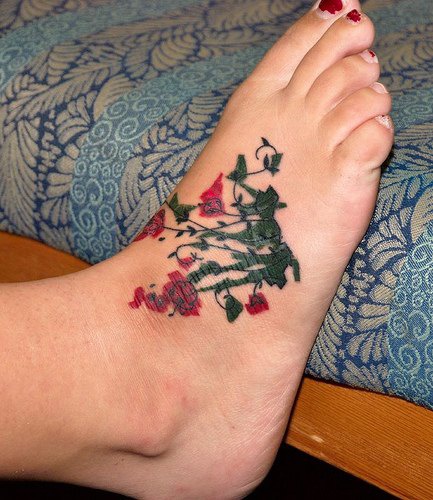 脚背绿色和红色的花朵纹身图案
