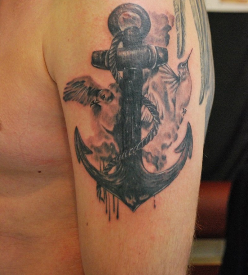 手臂黑色的船锚与鸟类纹身图案