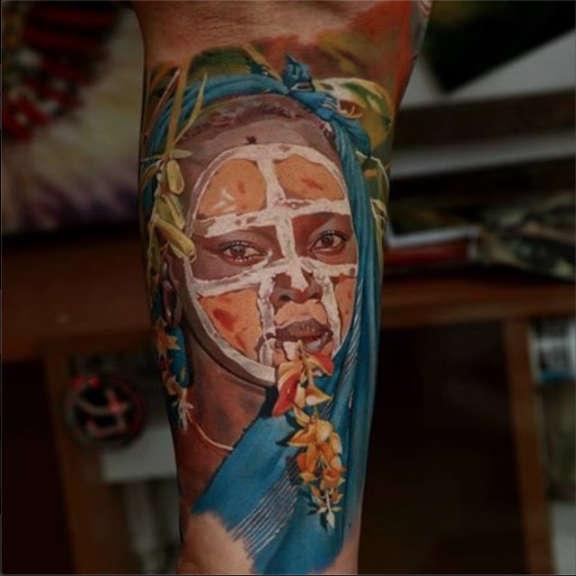 写实风格的彩色部落男子与鲜花手臂纹身图案