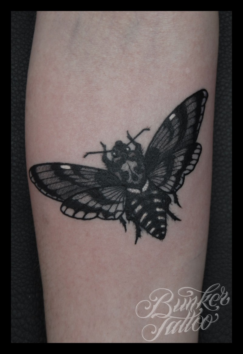 写实风格黑色飞蛾与骷髅手臂纹身图案
