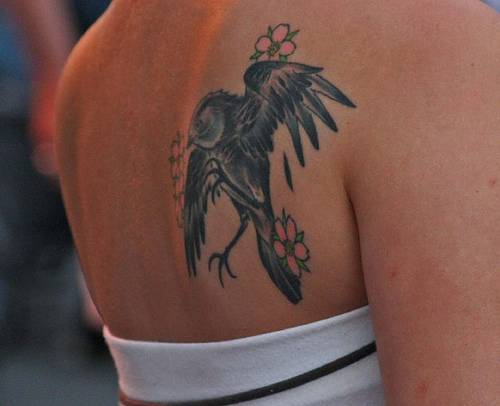 背部黑色乌鸦与花朵纹身图案