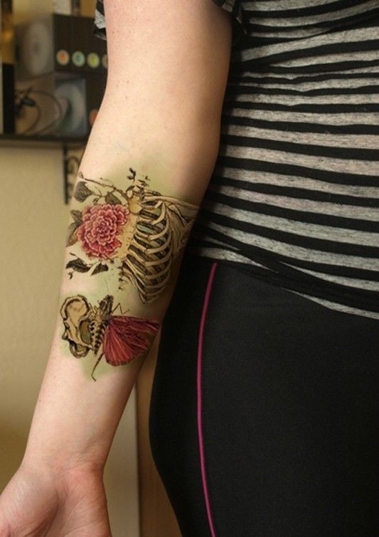 手臂有趣的彩色写实骨架与花朵纹身图案