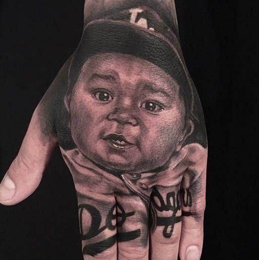 手背写实自然的黑色小宝贝肖像纹身图案