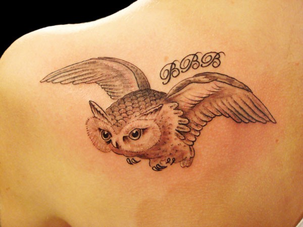 背部展翅的猫头鹰和字符纹身图案