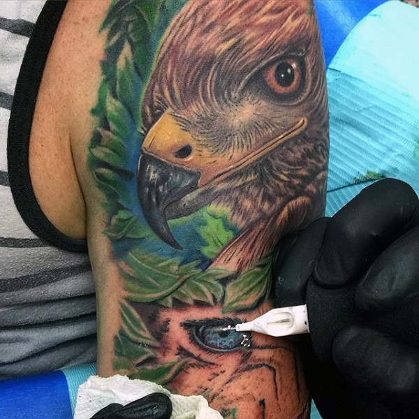 手臂惊人的彩绘和动物眼睛与鹰纹身图案