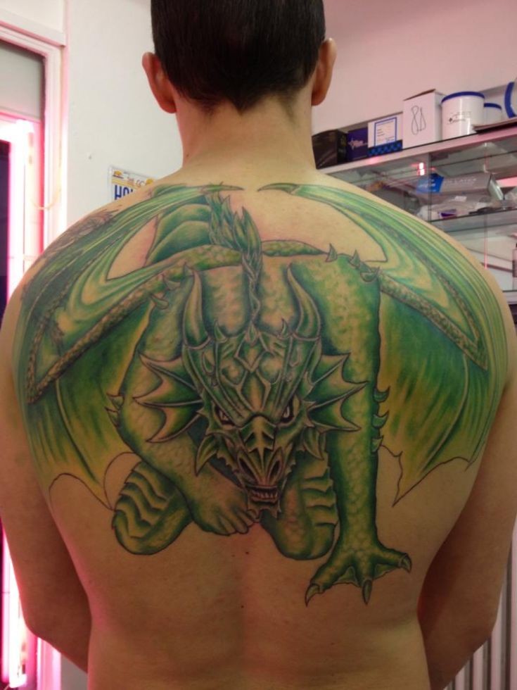男子背部绿色的龙纹身图案