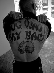 男性背部黑色字母与狗头像纹身图案