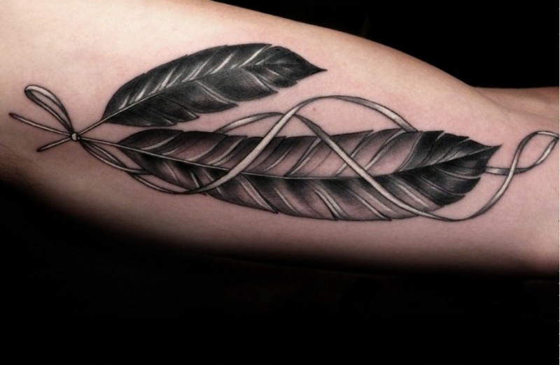手臂灰色的羽毛与丝带纹身图案