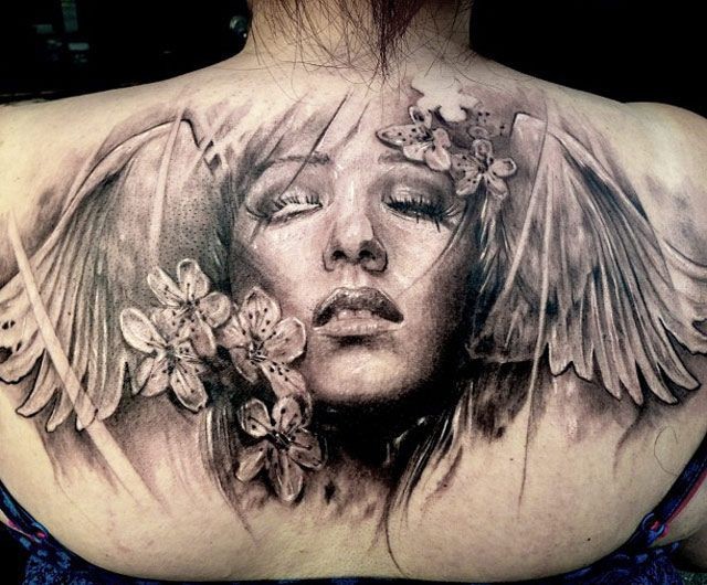 背部写实风格黑灰女性脸与翅膀花朵纹身图案