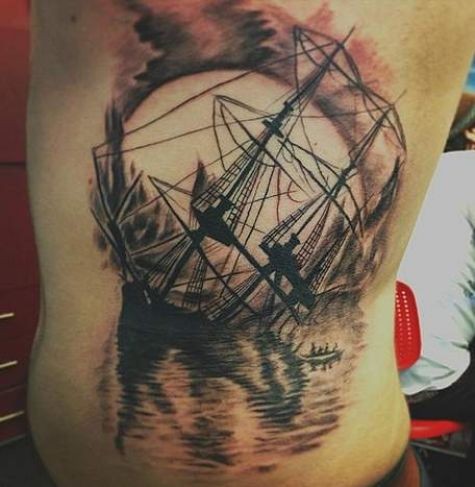 背部日落与沉没的帆船纹身图案