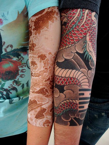 手臂红色的龙和风景纹身图案