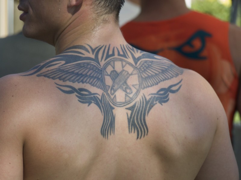 男性背部的黑色部落翅膀纹身图案