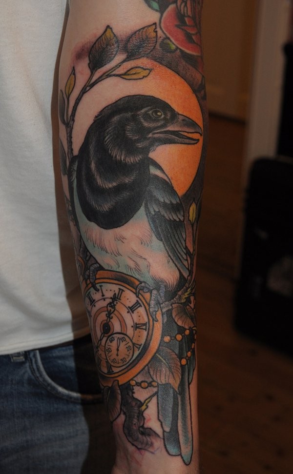 小臂带有时钟的彩色鸟纹身图案