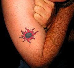 手臂黑色和红色的太阳纹身图案