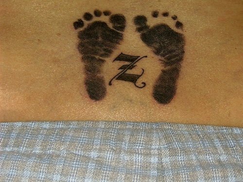 腰部黑色的人脚印与字符纹身图案