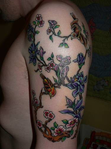 手臂彩色的小鸟和花朵树枝纹身图案