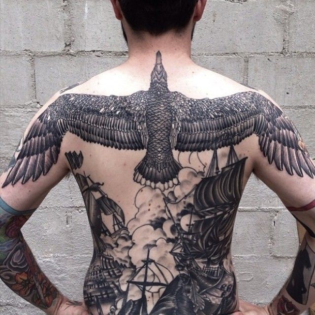 男性背部黑色的大鸟与帆船纹身图案
