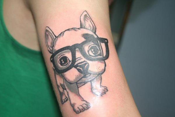 手臂上戴眼镜的可爱小狗纹身图案