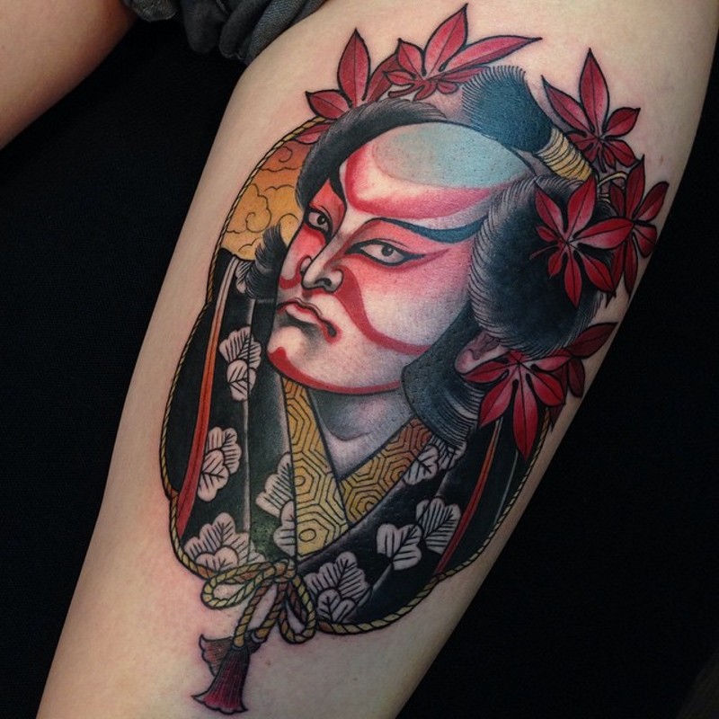 大腿彩色的亚洲男子肖像与枫叶纹身图案