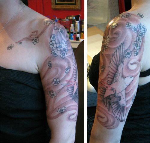 大臂自由飞行的鸽子和花朵纹身图案