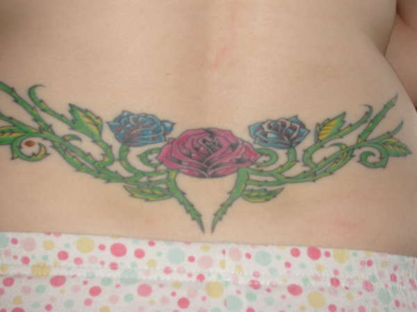 腰部红色和蓝色的玫瑰藤蔓纹身图案
