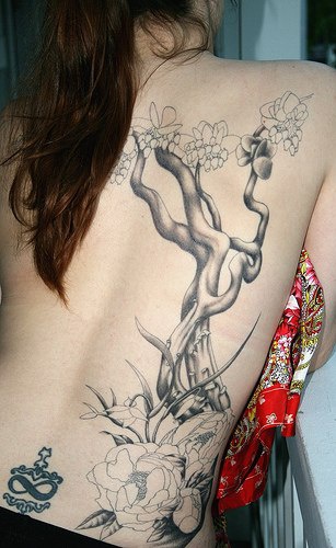 女性背部美丽的树枝与花朵纹身图案