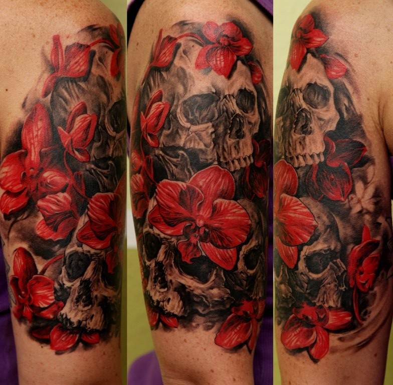 大臂美丽的红色兰花和黑色骷髅纹身图案