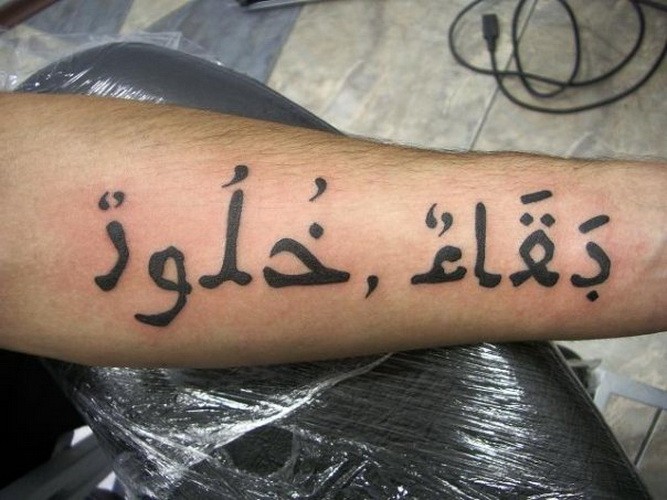 男子手臂粗糙的阿拉伯语字母纹身团