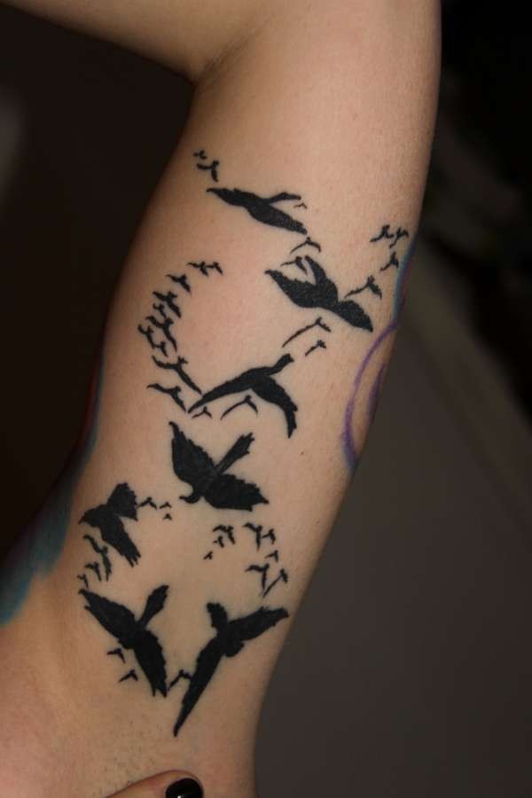 手臂一群不同大小的小鸟纹身图案