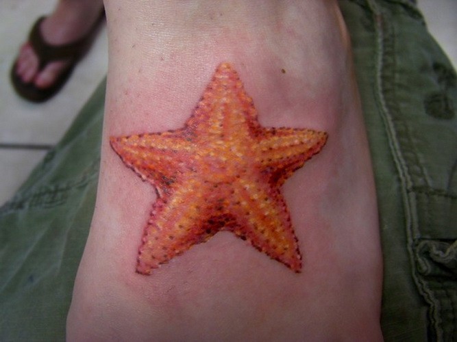 脚背美丽的橙色海星纹身图案
